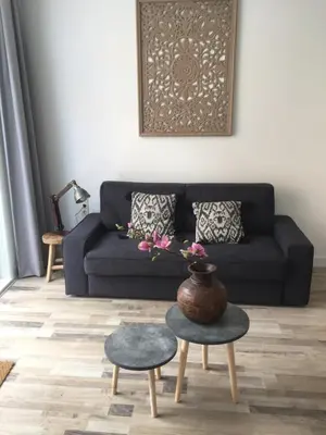 a living room with a couch and a table with a vase at appartementen zeespiegel in Zandvoort
