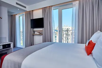 a hotel room with a large bed with a large window at Holiday Inn Express Amsterdam - City Hall by IHG in Amsterdam