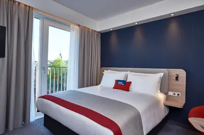 a bedroom with a large bed and a large window at Holiday Inn Express Amsterdam - City Hall by IHG in Amsterdam