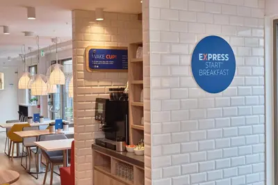 a restaurant with a sign on a wall at Holiday Inn Express Amsterdam - City Hall by IHG in Amsterdam