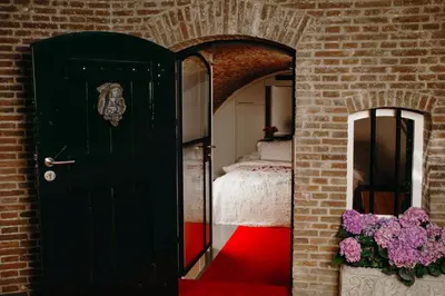 a bedroom with a black door and a red carpet at UKI-Hotel in Utrecht