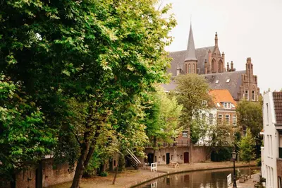 a city with a river and a building with a church at UKI-Hotel in Utrecht