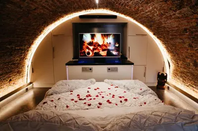 a bedroom with a bed with a fire in the background at UKI-Hotel in Utrecht