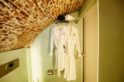 a white robe hanging on a wall next to a door at UKI-Hotel in Utrecht