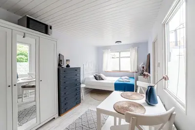 a white room with a table and a bedroom at Jopie's Guesthouse in Zandvoort