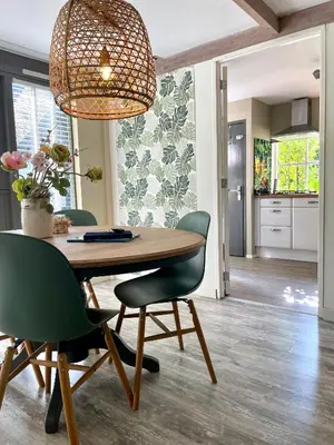 a dining room with a wooden table and green chairs at Goditi La Vita in Hem