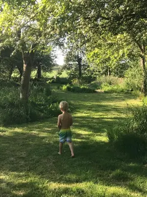 a young boy standing in the grass in a field at Goditi La Vita in Hem