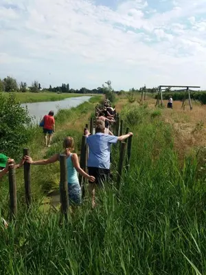 a group of people standing on a fence near a river at Goditi La Vita in Hem