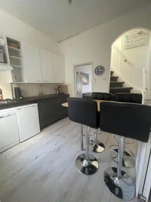 a kitchen with a table and stools in a room at SteR Appartement Zandvoort in Zandvoort