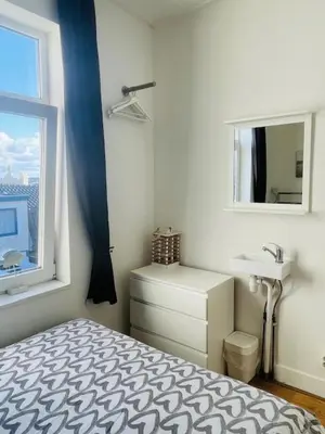 a bedroom with a bed and a sink and a window at SteR Appartement Zandvoort in Zandvoort