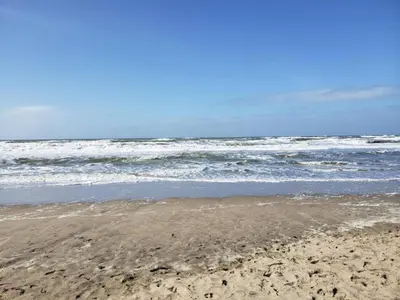 a sandy beach with the ocean in the background at Bungalow in Noordwijkerhout near Lake in Noordwijkerhout