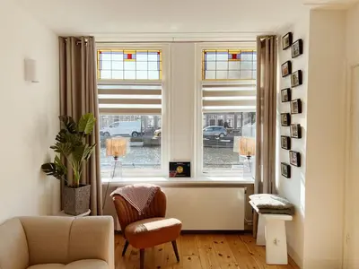 a living room with a chair and a window at Oudegracht Alkmaar in Alkmaar