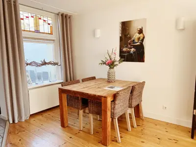 a dining room with a wooden table and chairs at Oudegracht Alkmaar in Alkmaar