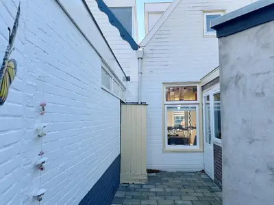 a white house with a door and a window at Oudegracht Alkmaar in Alkmaar