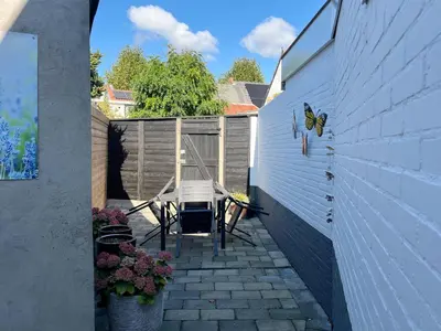 a patio with a table and a butterfly on the wall at Oudegracht Alkmaar in Alkmaar