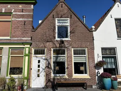 a brick house with a white door and windows at Oudegracht Alkmaar in Alkmaar