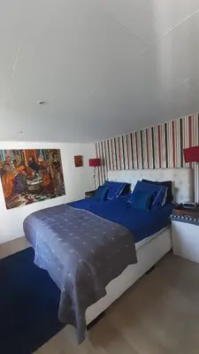a bedroom with a large bed with blue sheets at kitty
