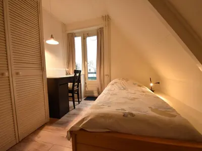 a bedroom with a bed and a desk with a window at Comfortable Holiday Home in Bergen in Bergen