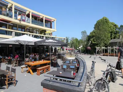 a patio with tables and chairs and a building at Comfortable Holiday Home in Bergen in Bergen