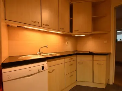 a kitchen with wooden cabinets and a sink at Comfortable Holiday Home in Bergen in Bergen