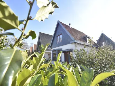 a white house with a blue roof and trees at Comfortable Holiday Home in Bergen in Bergen