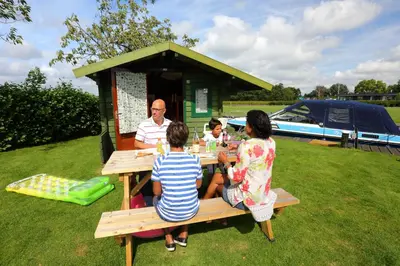 a group of people sitting at a picnic table at Camping Recreatiepark Aalsmeer in Aalsmeer