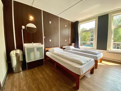 a hotel room with two beds and a mirror at Hostel Utopia in Amsterdam