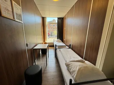 a row of beds in a room with a window at Hostel Utopia in Amsterdam