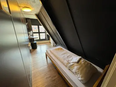 a small bed in a room with a wall at Hostel Utopia in Amsterdam
