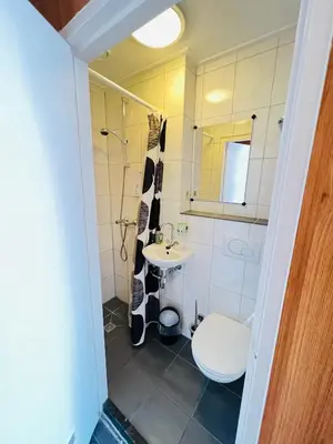 a bathroom with a sink and a toilet and a mirror at Hotel Sharm in Amsterdam