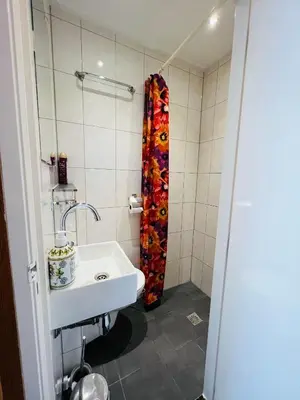 a bathroom with a sink and a shower curtain at Hotel Sharm in Amsterdam