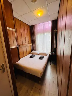 a bedroom with a bed in a room with a window at Hotel Sharm in Amsterdam