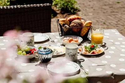 a table with a basket of food and a basket of fruit at B&B Wijk aan Duin in Beverwijk