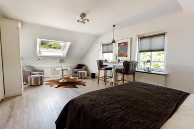 a bedroom with a bed and a table and chairs at B&B Wijk aan Duin in Beverwijk