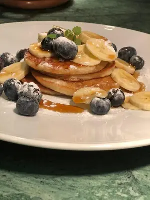 a plate with pancakes and blueberries on a table at Slapen bij hofman in Alkmaar