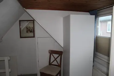 a stairway with a chair and a window at Sea Star Egmond aan Zee in Egmond aan Zee