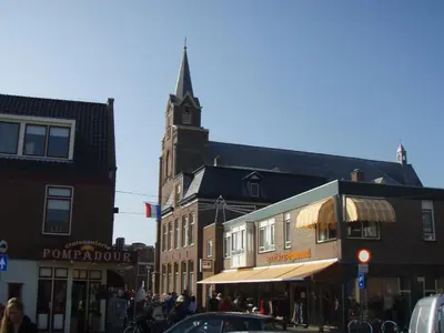 a building with a clock tower on a city street at Sea Star Egmond aan Zee in Egmond aan Zee