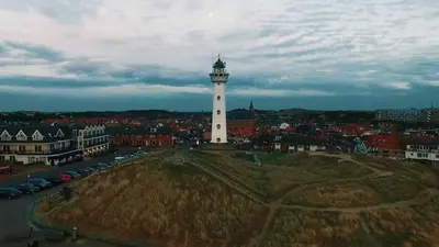 a lighthouse in the middle of a city with cars at Sea Star Egmond aan Zee in Egmond aan Zee