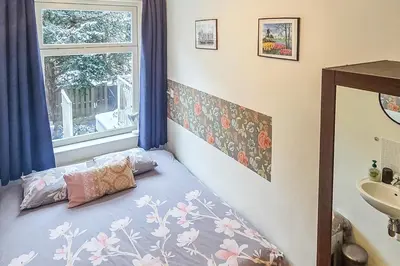a bedroom with a bed with a window and a sink at B&B West City Amsterdam in Amsterdam