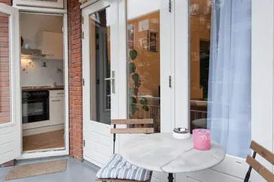 a small table on a porch with a table at B&B West City Amsterdam in Amsterdam