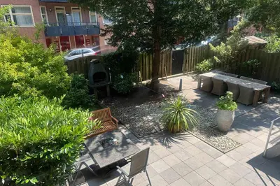 a patio with couches and a grill in a backyard at B&B West City Amsterdam in Amsterdam