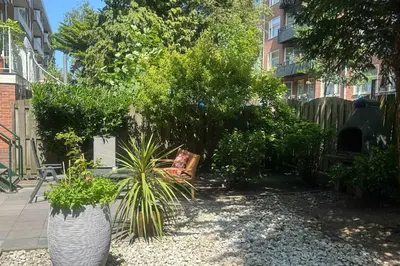 a garden with two large white vases and plants at B&B West City Amsterdam in Amsterdam
