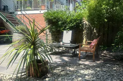 a patio with a table and a chair in a garden at B&B West City Amsterdam in Amsterdam