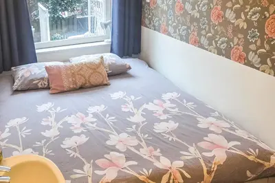 a bed in a bedroom with a flower patterned wall at B&B West City Amsterdam in Amsterdam