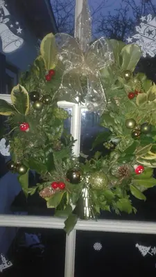 a christmas wreath on top of a window at B&B Marialin in Wijdewormer