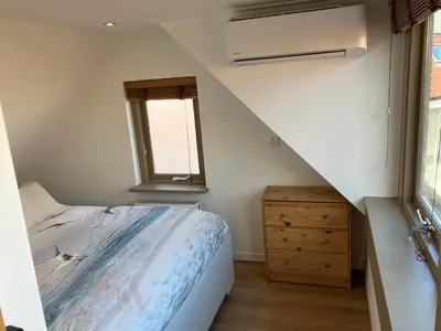 a small bedroom with a bed and a window at Es Vedra in Noordwijk aan Zee