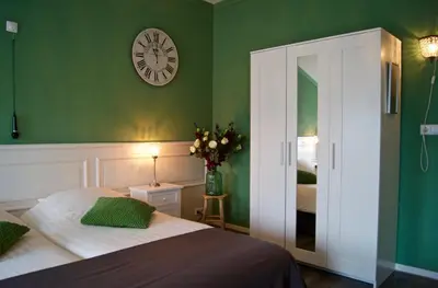 a bedroom with a bed and a clock on the wall at The Studio Guesthouse in Volendam