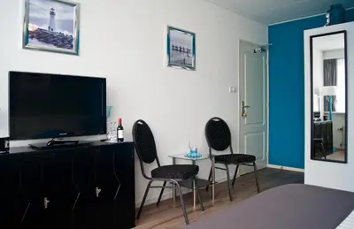 a living room with two chairs and a flat screen tv at The Studio Guesthouse in Volendam
