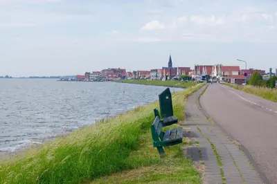 a bench on the side of a road next to the water at The Studio Guesthouse in Volendam