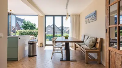 a kitchen and dining room with a table and chairs at Goudkust 3 'At Sea' in Bergen